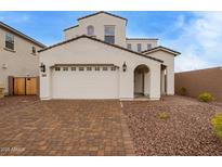 Elegant two-story home featuring a charming front yard with brick pavers and a two-car garage at 7725 W Crabapple Dr, Peoria, AZ 85383