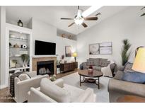 Cozy living room features a fireplace, vaulted ceilings, and comfortable seating arrangement at 850 E Vaughn Ave, Gilbert, AZ 85234