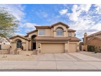 Stunning two-story home showcasing lush landscaping, a three-car garage, and a charming front courtyard at 1307 E Desert Broom Way, Phoenix, AZ 85048