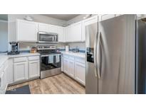 Bright kitchen with stainless steel appliances, white cabinets, and blue backsplash at 20100 N 78Th Pl # 2098, Scottsdale, AZ 85255