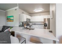 Modern kitchen featuring white cabinets, stainless steel appliances, and a breakfast bar at 20100 N 78Th Pl # 2098, Scottsdale, AZ 85255