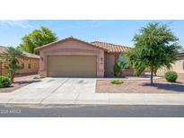 Charming single-story home featuring a well-maintained lawn and a two-car garage at 25073 W Dove Trl, Buckeye, AZ 85326