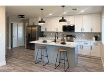 Beautifully updated kitchen with stainless steel appliances, an island with barstool seating, and stylish backsplash at 3345 E Edgewood Ave, Mesa, AZ 85204