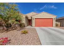 Charming single-story home with desert landscaping, a red garage door, and a matching front door at 4402 W Bush Bean Way, San Tan Valley, AZ 85144