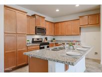 Eat-in kitchen island includes granite countertops, stainless steel appliances, and ample storage space at 4609 S 122Nd S Dr, Avondale, AZ 85323