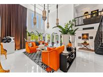 Bright, open living room with soaring ceilings, unique light fixtures, and stylish, modern furniture at 7242 E Joshua Tree Ln, Scottsdale, AZ 85250