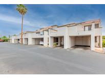 View of condo buildings, car ports, and landscaping including palm tree against a blue, slightly cloudy sky at 7755 E Thomas Rd # 7, Scottsdale, AZ 85251