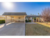 Single level home showcasing desert landscaping, a two car carport, and block fence at 10521 W Roundelay Cir, Sun City, AZ 85351