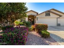 Charming single-story home featuring colorful desert landscaping, a three-car garage and a welcoming entrance at 13825 W Montebello Ave, Litchfield Park, AZ 85340