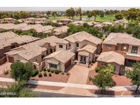 Aerial view showcases the property's tile roof, landscaping, neighborhood, and its proximity to a beautiful golf course at 14561 W Hidden Terrace Loop, Litchfield Park, AZ 85340