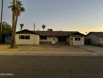 Charming single-story home featuring a quaint front porch, mature palm trees, and desert landscaping at 1533 W 7Th St, Tempe, AZ 85281