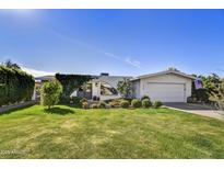 Charming home with a well-maintained lawn, a two-car garage, and manicured landscaping at 3429 E Indianola Ave, Phoenix, AZ 85018