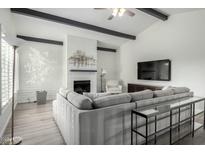 Bright living room features vaulted ceilings, white brick fireplace, and large sectional sofa at 4800 N 68Th St # 385, Scottsdale, AZ 85251
