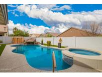 A luxurious pool with an attached hot tub and rock waterfall creates a perfect outdoor retreat at 714 W Desert Hills Dr, San Tan Valley, AZ 85143