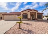 Inviting single-story home featuring a three-car garage and manicured desert landscaping at 8335 W Berridge Ln, Glendale, AZ 85305