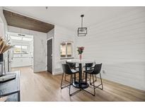 Bright dining area features a marble table, black chairs, a modern light fixture, and a shiplap accent wall at 9450 E Becker Ln # 2019, Scottsdale, AZ 85260
