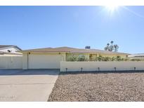 Charming single-story home featuring a brick accent wall, two-car garage, and desert landscaping at 1201 E Gemini Dr, Tempe, AZ 85283