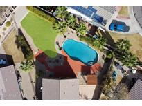 A stunning aerial view showcases a sparkling pool, lush lawn, and solar panels on the home's roof at 23225 N 23Rd Pl, Phoenix, AZ 85024