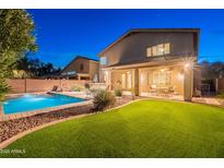 Expansive backyard featuring pool, covered patio, artificial grass, and desert landscaping at 26711 N 21St Dr, Phoenix, AZ 85085