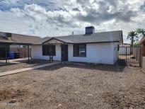 Well-maintained single-story home with a carport and easy desert landscaping, fenced for privacy at 3123 W Holly St, Phoenix, AZ 85009