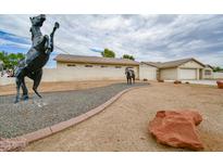 Spacious desert landscaped front yard with horse statues and white exterior home at 6020 E Shea Blvd, Scottsdale, AZ 85254