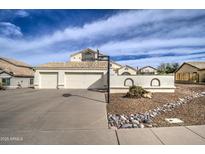 Charming home featuring a two-car garage, basketball hoop and desert landscaping at 6614 E Portia St, Mesa, AZ 85215