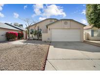 Charming single-Gathering home with a two-car garage, neutral paint, rock landscaping, and lush bougainvillea at 8729 W Grovers Ave, Peoria, AZ 85382