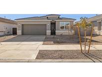 Charming single-story home with a gray exterior, well-kept landscaping, and a two-car garage at 15397 W Hackamore Dr, Surprise, AZ 85387