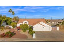 Beautiful front exterior featuring lush desert landscaping and a three-car garage, creating an inviting curb appeal at 2020 E Norwood St, Mesa, AZ 85213