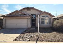 Charming single-story home with a two-car garage, desert landscaping, and an arched entryway at 2303 E Wescott Dr, Phoenix, AZ 85024