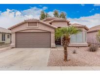 Charming single-story home with a two-car garage and a desert-landscaped yard, complete with a mature palm tree at 2704 E Anderson Dr, Phoenix, AZ 85032