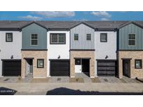 A modern townhome exterior showcasing neutral paint, brick accents, and black garage doors at 2818 W Eagle Talon Rd, Phoenix, AZ 85085