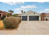 Three car garage with dark doors in desert landscaping with mature trees and bushes at 3793 S Seton Ave, Gilbert, AZ 85297