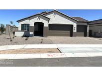 Charming single-story home with a brown two-car garage and low maintenance landscaping at 43527 N Wollemi St, Queen Creek, AZ 85140