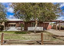 Charming single-story home featuring a well-manicured front yard and a rustic wooden fence at 6720 W Medlock Dr, Glendale, AZ 85303