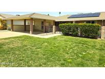 Single-story home showcasing a well-manicured lawn, carport, and gated patio area at 10816 W Venturi Dr, Sun City, AZ 85351