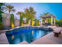 Inviting pool area with a spa and covered patio, surrounded by lush landscaping at 12970 W Kokopelli Dr, Peoria, AZ 85383