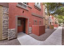 Charming townhome exterior with red stucco, stone accents, and well-maintained landscaping at 1920 E Bell Rd # 1019, Phoenix, AZ 85022