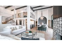 Bright, modern living room with soaring ceilings, black beams, and comfortable white sofas at 4434 E Camelback Rd # 128, Phoenix, AZ 85018