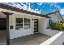 Inviting exterior featuring a white brick facade, black trim, and a modern front door, complete with manicured landscaping at 4721 N 24Th St, Phoenix, AZ 85016
