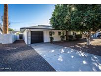 Charming single-story home featuring a driveway, well-maintained landscaping and a black garage door at 4729 N 24Th St, Phoenix, AZ 85016