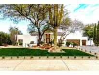 Stunning home featuring well-manicured lawn, desert landscaping, beautiful trees and a water feature near the front entryway at 8713 N 80Th Pl, Scottsdale, AZ 85258