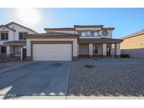 Charming two-story home features a two-car garage, desert landscaping, and a welcoming front porch at 9325 W Hazelwood St, Phoenix, AZ 85037