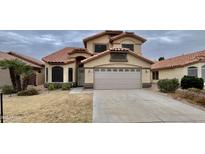 Charming home featuring a well-maintained yard and a two-car garage, with a beautiful red tile roof at 9761 W Yukon W Dr, Peoria, AZ 85382