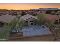 Charming single-story home with desert landscaping, concrete driveway, and mountain views at sunset at 22139 N Van Loo Dr, Maricopa, AZ 85138