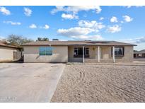 Inviting single-story home with a classic desert landscape and a covered porch entrance at 2215 N 58Th Dr, Phoenix, AZ 85035