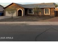 Single-story house featuring neutral stucco, a gray roof, and desert landscaping at 304 E Madison St, Avondale, AZ 85323