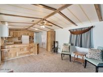 Living room featuring wood beams, ceiling fan, and cozy seating area with natural light at 3330 E Main St # 250, Mesa, AZ 85213