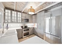 Bright kitchen features stainless steel appliances, gray cabinets, white countertops, and a unique wood paneled ceiling at 7126 N Via Nueva --, Scottsdale, AZ 85258