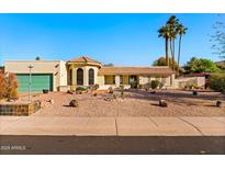 Charming single-story home featuring desert landscaping, a tile roof, and a two-car garage at 1031 W Indian Hills Pl, Phoenix, AZ 85023